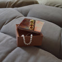 Scatola portagioie design Tatamama in ambientazione su divano