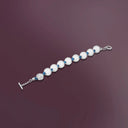 Bracciale Sfere indossato, dettaglio delle sfere metalliche su sfondo scuro.