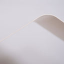 Dettaglio di una superficie curva bianca su sfondo chiaro, con linee eleganti e moderne.