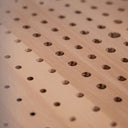 Superficie di legno con fori regolari, ideale per progetti di falegnameria e artigianato.