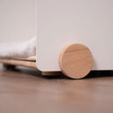 Dettaglio di una cuccia per cani e gatti con supporto in legno, progettata per interni.