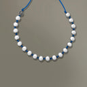 Collana Sfere di design, vista frontale con sfere metalliche su sfondo neutro.