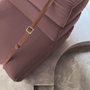 Dettaglio cinturino in pelle su poltrona Docker in velluto rosa