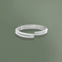 Bracciale gioiello donna triangolare due giri indossato su sfondo verde