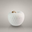 Mela luxury incastonata design bianco con dettagli metallici su sfondo chiaro