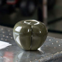 Scultura decorativa Mela del Peccato Accidia ambientata su superficie moderna